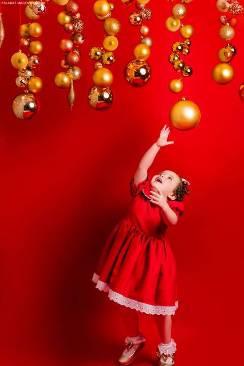 criança tentando pegar a bolinha de natal'