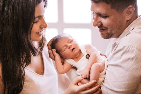 retrato pai e mãe carregando bebê'
