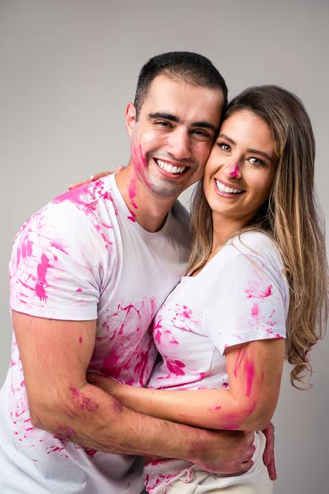 Casal sorrindo após descoberta no ensaio de revelação'