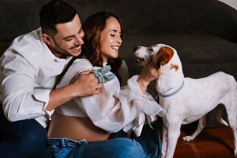 Momento espontâneo do casal interagindo com a Amora durante o ensaio de gravidez no estúdio.'