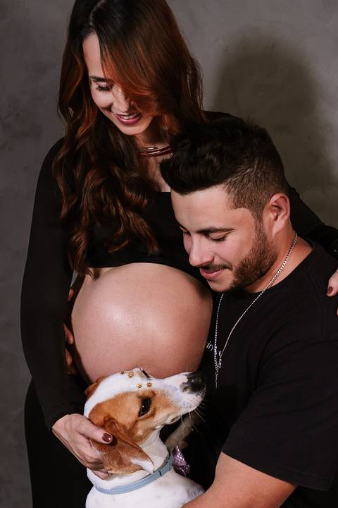 Momento íntimo do casal celebrando a gestação, com destaque para a barriga em clima de carinho e conexão.'