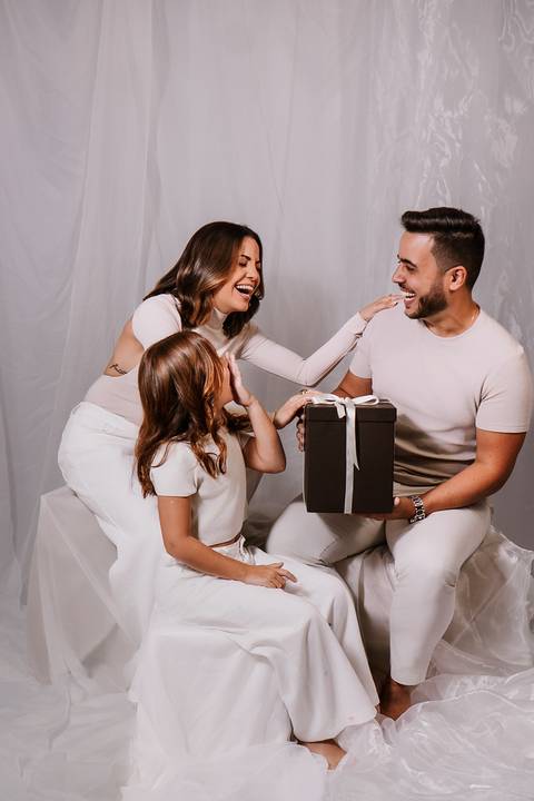 Cena divertida da família no momento da revelação, com Sarah e Malu interagindo antes de descobrir o nome da bebê.'