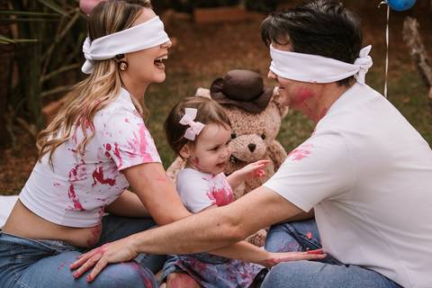 Pais vendados tocando as mãos da filha antes da revelação'