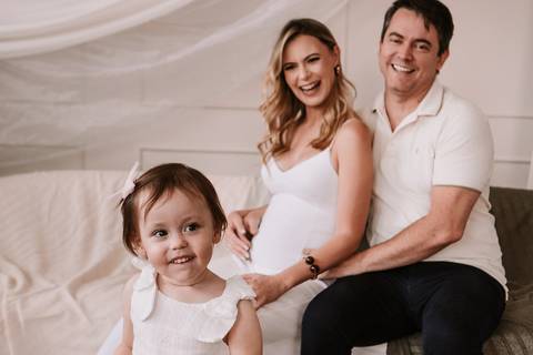  Família sentada junta sorrindo para a câmera'