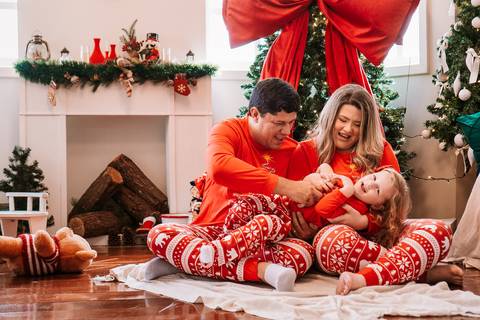 Família reunida sentada no cenário com pijamas natalinos'