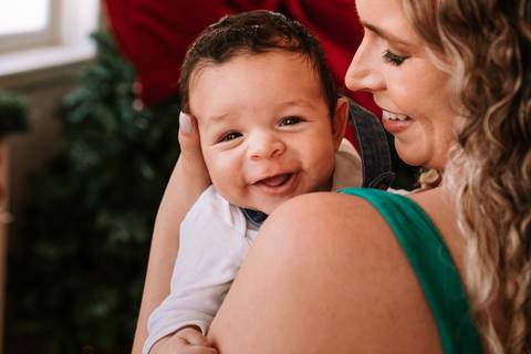  Bebê sorrindo no colo da mãe em clima de alegria'
