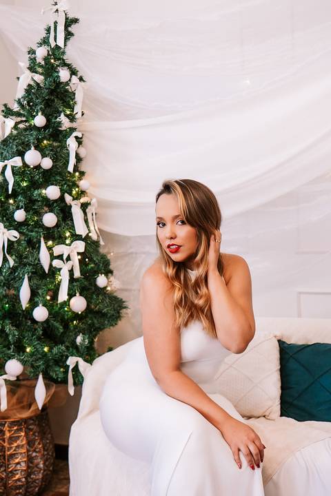 Retrato em luz suave ao lado da árvore branca de Natal.'
