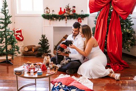 Cena do casal montando a mesa de Natal no estúdio.'