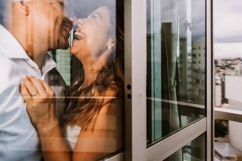 Casal sorrindo em ambiente interno durante ensaio pré casamento'