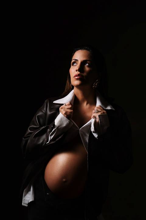     Retrato artístico com iluminação dramática valorizando a gestação'