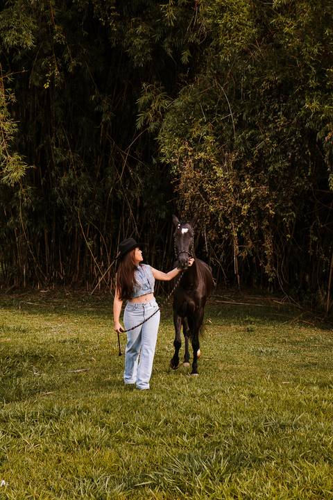     Reviana conduzindo um cavalo durante ensaio no rancho'