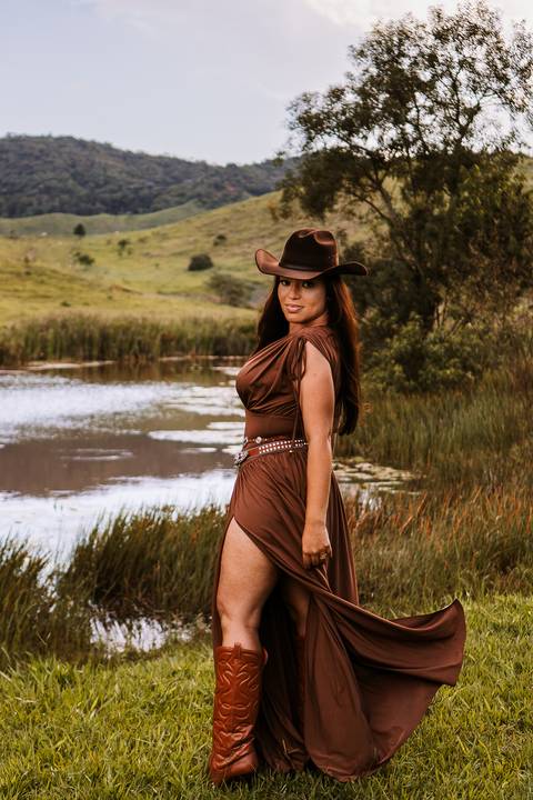     Mulher em vestido longo contemplando a paisagem do rancho'