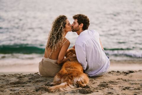     Momento romântico do casal com o pet observando o mar'