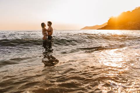     Noivos entrando no mar durante ensaio pré casamento'