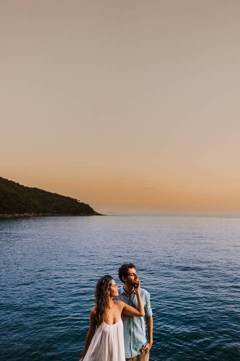     Retrato do casal com o mar ao fundo durante o fim de tarde'