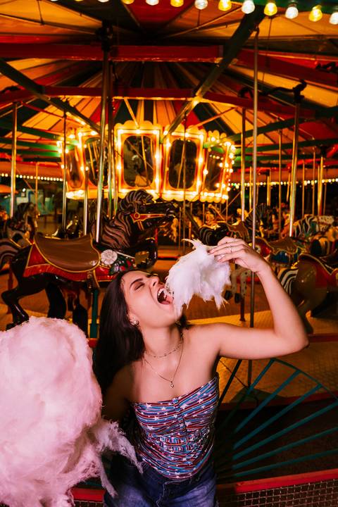     Retrato espontâneo de debutante em meio às luzes do parque de diversões'