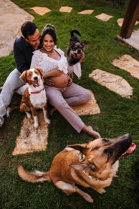     Gestante ao lado do marido e dos pets durante ensaio de família'