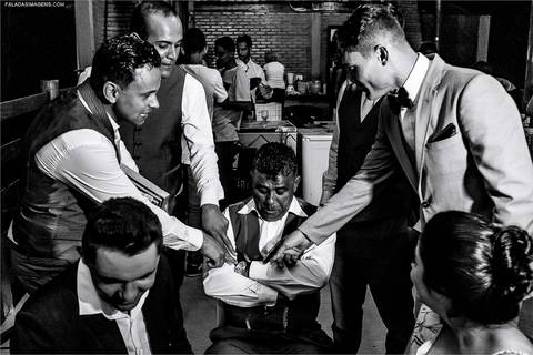 Noivo passando gravata durante seu casamento '