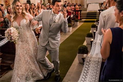 noivo saindo emocionado fazendo simbolo de rock n roll para convidados na igreja em joão monlevade
'