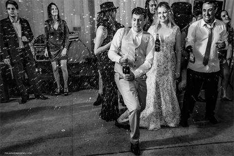 noivo comemorando, alegre, feliz, jogando champagne nos convidados'