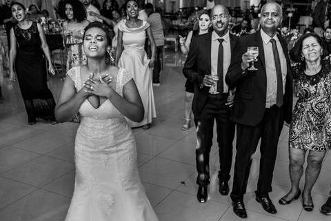 noiva emocioada ao ver o noivo cantando durante festa de casamento'