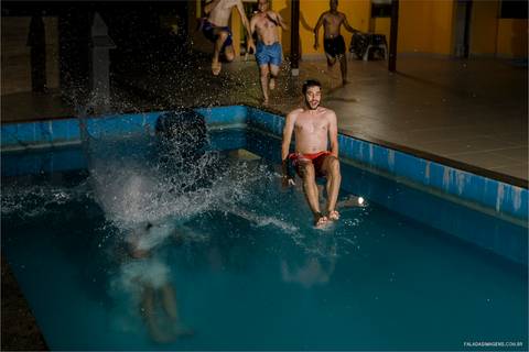 padrinhos pulando na piscina  no final da festa de casamento '