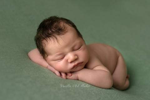 baby lying down on his hand'