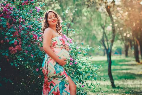 gestante sorrindo com as mãos na barriga, no Parque dos Ipes, em Santa Bárbara d'Oeste - SP'