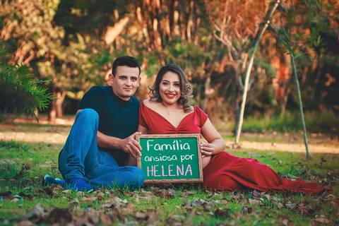 papai e mamãe segurando a plaquinha escrito 