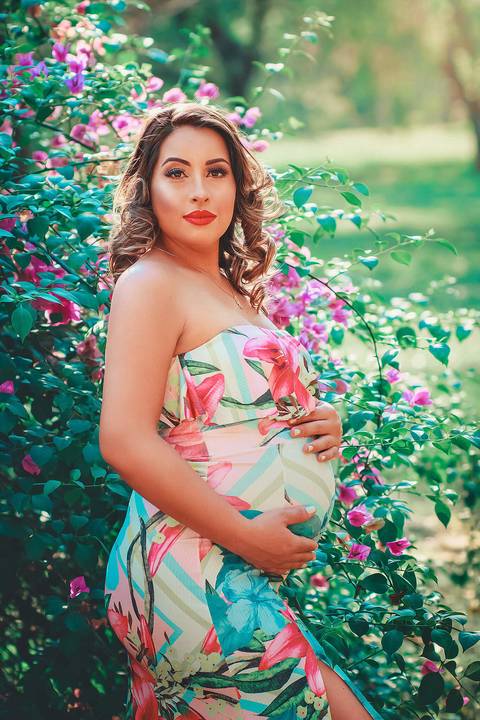 gestante linda encarando a câmera e mãos na barriga, no Parque dos Ipes, em Santa Bárbara d'Oeste - SP'