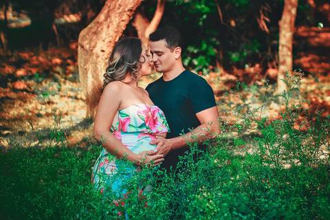 gestante e seu marido com a mão na barriga dela, de olhos fechados se amando, no Parque dos Ipes, em Santa Bárbara d'Oeste - SP'