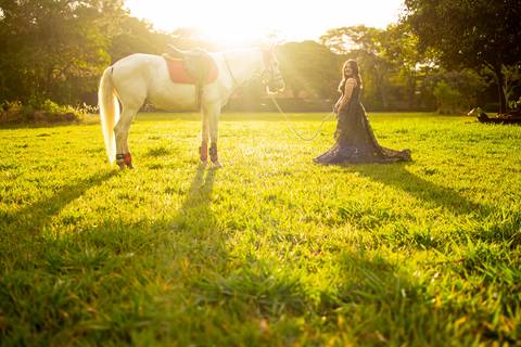 Isa, em seu ensaio de 15 anos em Ribeirão Preto, demonstra toda sua paixão e carinho pelo cavalo que marcou este momento especial. O close revela a conexão única entre os dois, com destaque para o vestido preto elegante e a delicadeza do toque, mostrando '