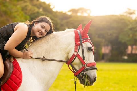 Isa, em seu ensaio de 15 anos em Ribeirão Preto, demonstra toda sua paixão e carinho pelo cavalo que marcou este momento especial. O close revela a conexão única entre os dois, com destaque para o vestido preto elegante e a delicadeza do toque, mostrando '
