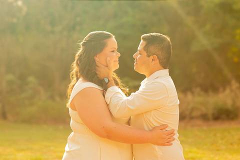 Fotógrafo de casamento em Ribeirão Preto captura Thays e Lucas abraçando o filho com risos, um retrato de família em preto e branco.'