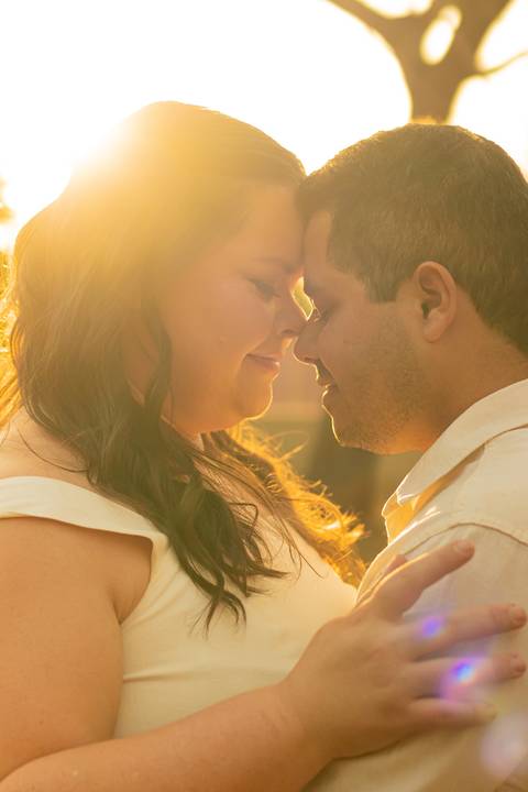 Fotógrafo de casamento em Ribeirão Preto captura Thays e Lucas abraçando o filho com risos, um retrato de família em preto e branco.'