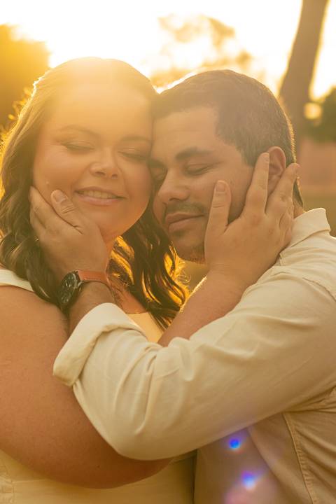 Fotógrafo de casamento em Ribeirão Preto captura Thays e Lucas abraçando o filho com risos, um retrato de família em preto e branco.'