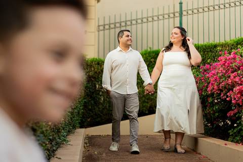 Fotógrafo de casamento em Ribeirão Preto captura Thays e Lucas abraçando o filho com risos, um retrato de família em preto e branco.'