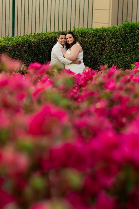 Fotógrafo de casamento em Ribeirão Preto captura Thays e Lucas abraçando o filho com risos, um retrato de família em preto e branco.'