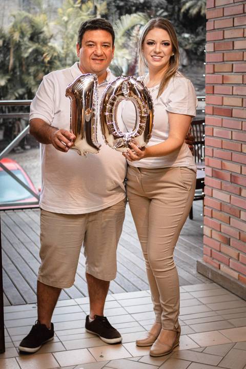 Casal segurando balão nº 10 simbolizando 10 anos de casados'