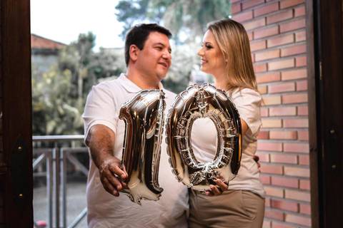 Casal segurando balão nº 10 simbolizando 10 anos de casados'