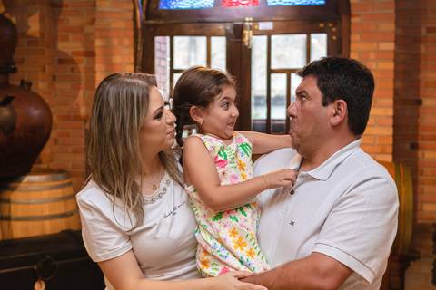 pai , mãe e filha abraçados e fazendo careta'