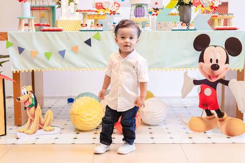 criança na frente da mesa de decoração de festa infantil tema Mickey - Turma do Mickey'