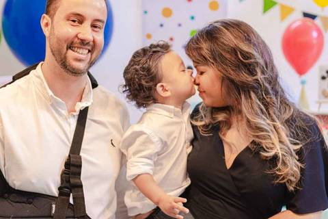 filho criança no colo da mãe beijando a mãe '