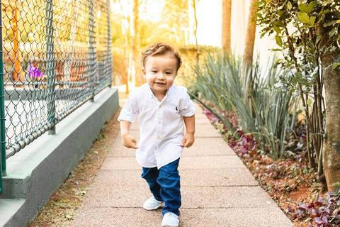 menino correndo no pátio no pôr do sl'