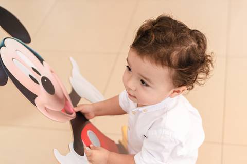 menino abraçando totem do Mickey'