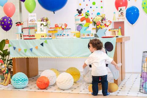 menino abraçando totem do Mickey'