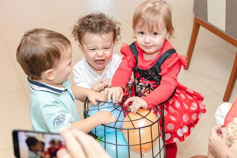 crianças brincando com balão na festa de aniversário infantil'
