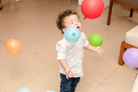criança brincando com balão na festa de aniversário infantil'