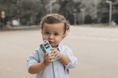 menino tomando suco no parque '