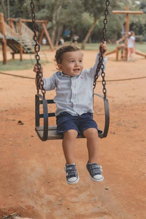 menino no balanço do parquinho'